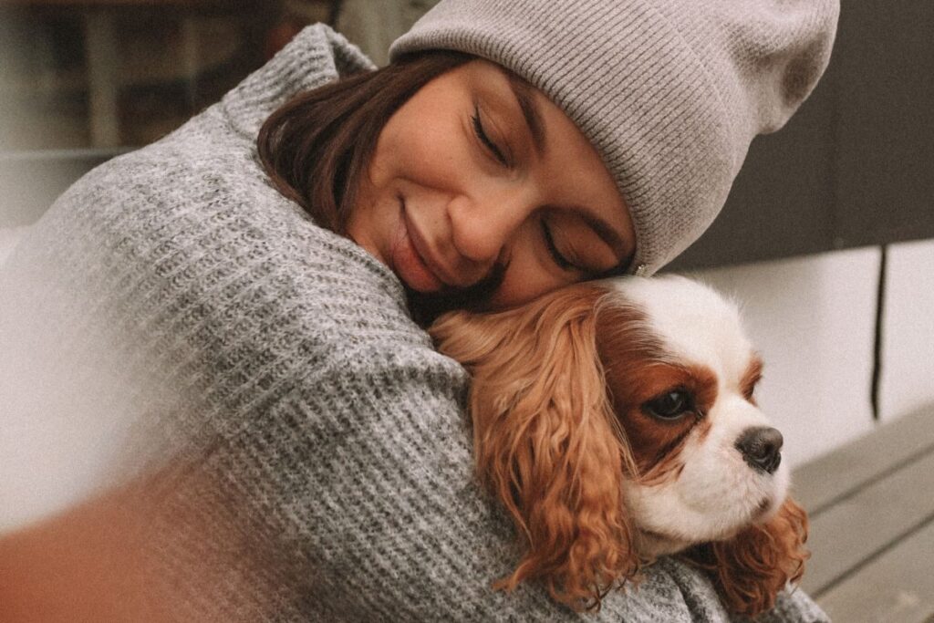 woman hugging a cavalier king charles puppy